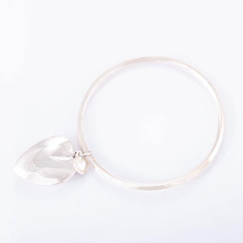 Our Sterling Silver Heart Bangle. Shown here, in hand-made 925 sterling, bevel-edged with a large puffed heart. As well as, with a small flat sterling heart. A truly elegant and unique piece. In short, it makes for a stunning gift idea, with twice the love. Or as a self-indulgent addition to any personal jewelry collection.