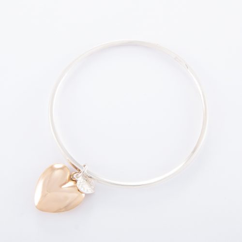 Our Sterling Silver Bangle with Gold Puffed Heart. Shown here, with a handcrafted bevel-edged, 925 sterling silver band. Also with a beautiful large puffed heart in plated gold. As well as, with a small sterling heart. It’s a truly unique and stunning piece. In short, the perfect self-indulgent purchase to add to your own jewelry collection. Or as the ultimate gift idea, with twice the love for somebody special.